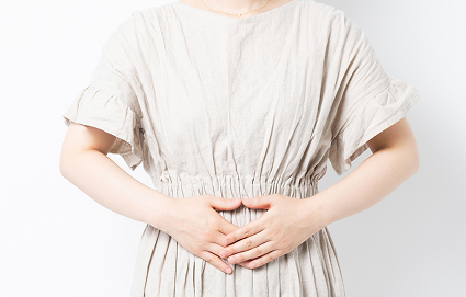 お腹を押さえる女性